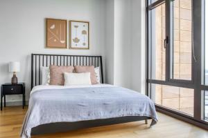 um quarto com uma cama grande e uma janela em Luxury Fort Point 1BR w WD Gym BOS-488 em Boston