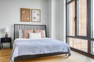 Un dormitorio con una cama grande y una ventana en Luxury Fort Point 1BR w WD Gym BOS-488, en Boston