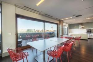 a dining room with a table and red chairs at Luxury Fort Point 1BR w WD Gym BOS-488 in Boston