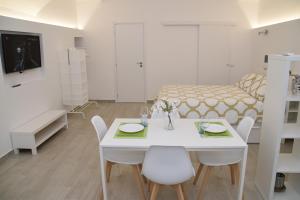 a white room with a table and chairs and a bed at Casetta Verga Loft in Catania