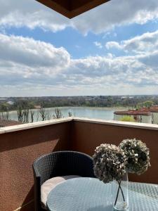 una mesa con un jarrón de flores en el balcón en Casa Aurora, en Segrate