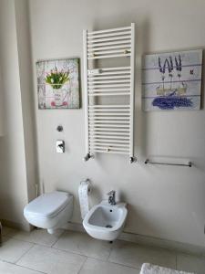 Baño blanco con aseo y lavamanos en Casa Aurora, en Segrate
