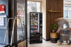 a vending machine in a restaurant with drinks in it at Hotel Khla Nice in Nice