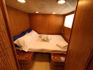 a small bed in the back of a boat at BOAT & BREAKFAST LUCRETIA, LUXURY yacht in Àrbatax