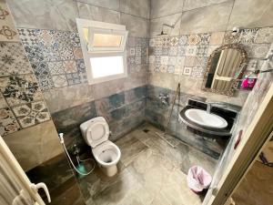 a bathroom with a toilet and a sink at Oasis Fighting Kangaroo in Dahab