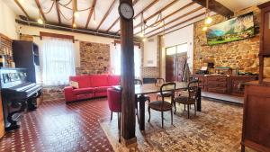 sala de estar con mesa y sofá rojo en 2-TUUL ETXEA, Habitación doble a 8 km de Bilbao, Baño compartido, en Galdakao