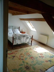 ein Schlafzimmer mit einem Bett und einem Teppich auf dem Boden in der Unterkunft Terres de Saône in Écuelles