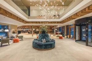 a large lobby with a blue couch in the middle at Alpenhotel Montafon in Schruns
