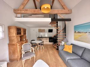 een woonkamer met een bank en een tafel bij Romantique petite chaumière près de Guérande in Saint-Lyphard