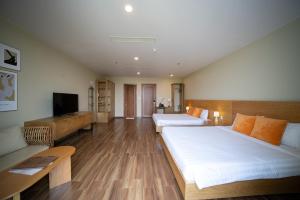 pokój hotelowy z 2 łóżkami i kanapą w obiekcie Sline Hotel and Apartment w mieście Thôn Trường Giang