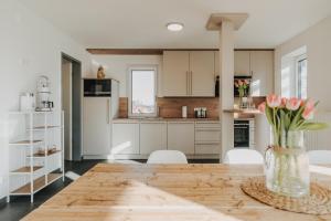 a kitchen with a wooden table and white cabinets at Penthousewohnung Bockhorn in Bockhorn