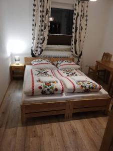 a bedroom with two beds and a window at Pokoje Czajka in Ochotnica Górna