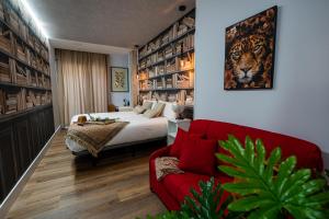 a bedroom with a bed and a red couch at Center Suite Acebedos in Santander