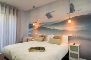 um quarto com uma cama grande com pássaros na parede em Center Suite Acebedos em Santander