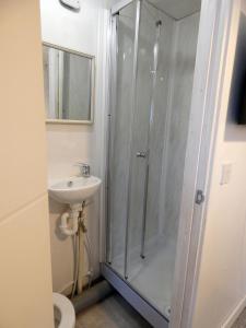 een badkamer met een douche en een wastafel bij Bridge Street En Suite Rooms in Merthyr Tydfil