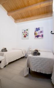 een slaapkamer met 2 bedden en een houten plafond bij A Casa di Sonia in Siracusa