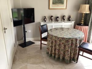 a dining room with a table and a tv at 4 Cois Glaisin View in Kilcarn