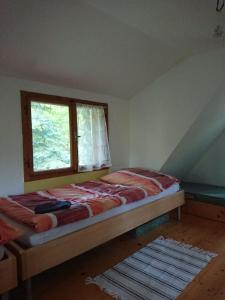 Giường trong phòng chung tại Roztomilá a utulná chata Azzy na samotě v lese.