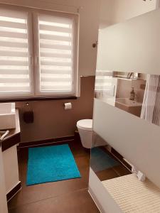 baño con aseo y alfombra azul en [E] ifeel home_ Adenau, en Adenau
