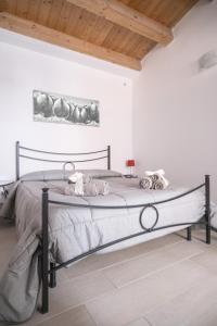a bed in a white bedroom with a wooden ceiling at A Casa di Sonia in Syracuse