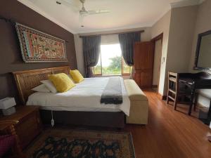 ein Schlafzimmer mit einem großen Bett und einem Fenster in der Unterkunft Ha'Penny Hill in Tzaneen