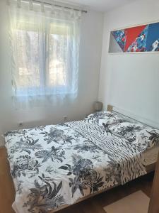 Apartment Vjera Ližnjan في ليجيان: سرير لحاف اسود وبيض ونافذة