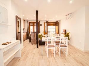 a kitchen and dining room with a white table and chairs at PRECIOSO PISO EN PLENO CENTRO Con PARKING OPCIONAL in Granada