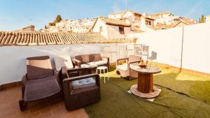 un patio con sofás y sillas en el techo en PRECIOSO PISO EN PLENO CENTRO Con PARKING OPCIONAL en Granada