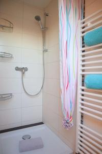 a bathroom with a shower with a colorful shower curtain at Ferienwohnung Neuwerk in Dorum-Neufeld