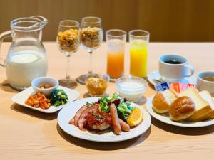 a table with plates of food and glasses of milk at APA Hotel Higashi Shinjuku Kabukicho in Tokyo