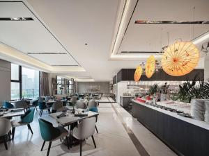 een restaurant met tafels en stoelen en een buffet bij Jinyun Jingjiang International Hotel in Jinyun
