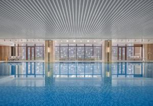 een groot zwembad in een gebouw met een plafond bij Jinyun Jingjiang International Hotel in Jinyun