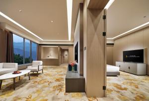 een hotelkamer met een bed en een televisie bij Jinyun Jingjiang International Hotel in Jinyun