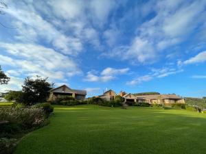 a large yard with houses on a green field at Ha'Penny Hill in Tzaneen