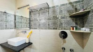 uma casa de banho com um lavatório, um espelho e uma parede em BluO 1BHK Medanta Medicity, Kitchen, Balcony, Lift em Gurgaon