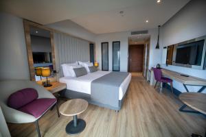um quarto de hotel com uma cama grande e uma secretária em Seven For Life Thermal Hotel em Kusadasi