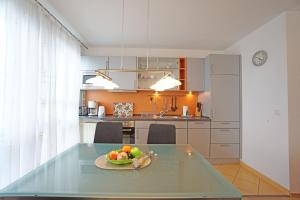a kitchen with a table with a bowl of fruit on it at Dünenresidenz mit Meerblick in Bansin