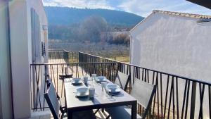 una mesa con tazas y platillos en el balcón en Les Papillons du Ventoux - La Petite Tortue - één slaapkamer met terras en Malaucène