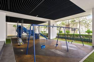 - une aire de jeux dans un bâtiment avec des balançoires bleues dans l'établissement Puchong Setiawalk Residence By Iconique Espace, à Puchong
