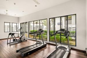 - une salle de sport avec 3 machines elliptiques et des fenêtres dans l'établissement Puchong Setiawalk Residence By Iconique Espace, à Puchong