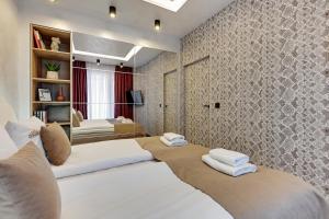 a bedroom with two beds with white towels on them at Downtown Apartments Riverside Granaria Deluxe in Gdańsk