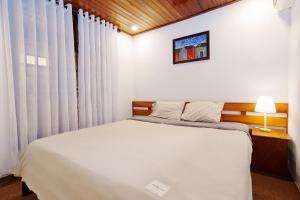 - une chambre avec un lit et une fenêtre avec des rideaux dans l'établissement An Hiên Homestay Hội An, à Hội An