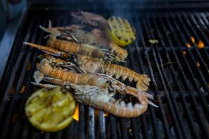 a group of lobsters and a lemon on a grill at Quinlan & Cooke Boutique Townhouse and QCs Seafood Restaurant in Cahersiveen