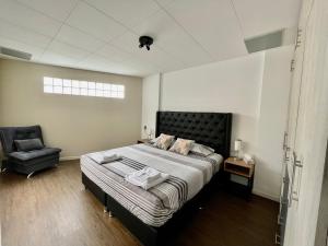 um quarto com uma cama grande e uma cadeira em Brand-new 2 bedroom apartment Sopocachi em La Paz