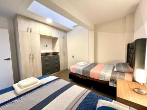 a bedroom with two beds and a desk and cabinets at Brand-new 2 bedroom apartment Sopocachi in La Paz