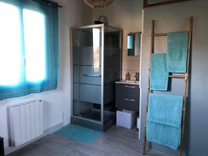 Un baño con ducha de cristal y lavabo. en Charmant gîte en Périgord vert, en Douchapt