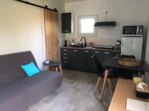 Una cocina y una sala de estar con un sofá y una mesa. en Charmant gîte en Périgord vert, en Douchapt