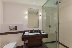 ein Badezimmer mit Waschbecken und Dusche in der Unterkunft Sarovar Portico Jaipur in Jaipur