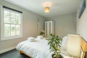 a bedroom with a white bed and a window at Cambridge 3 bedroom flat with private parking in Cambridge