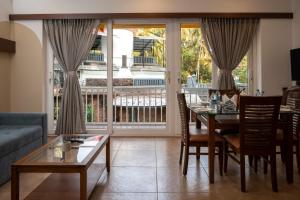Richmonde Ananta Elite Luxurious Villa & Apartments,Goa في باغا: غرفة معيشة مع طاولة وأريكة